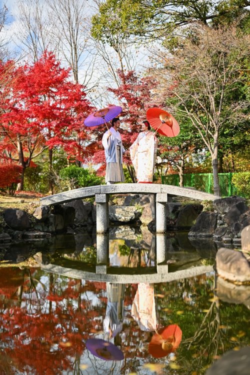 日本庭園の石橋を渡る新郎新婦