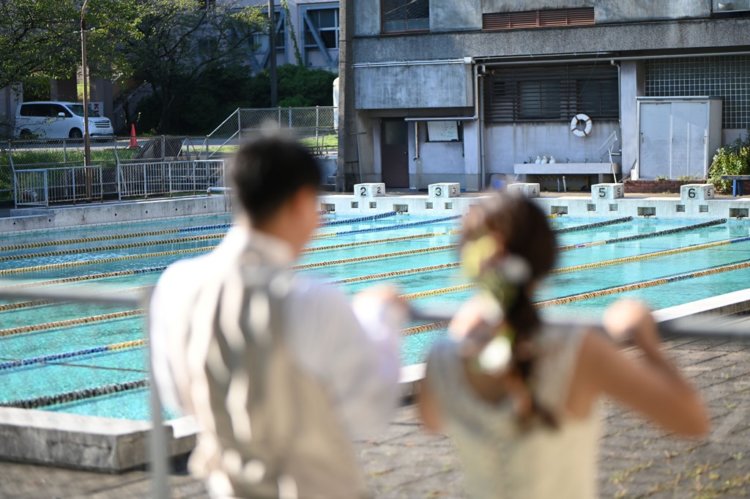 学校のプールをバックに撮った結婚写真