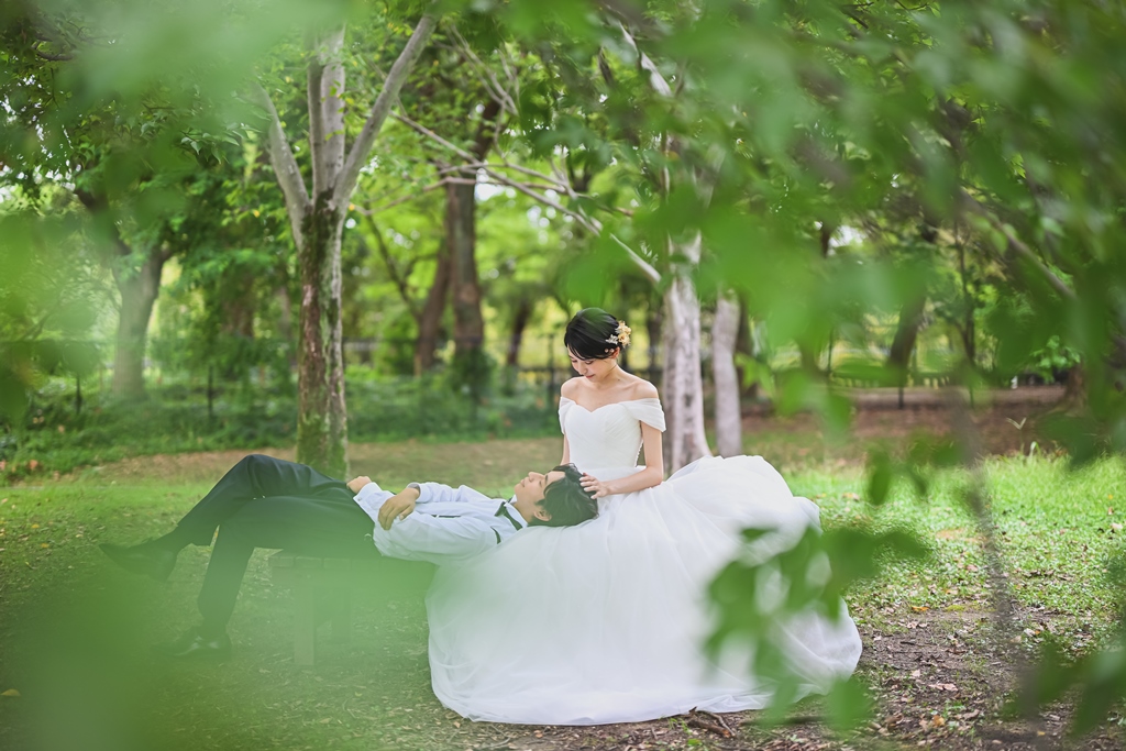 森の中のベンチで膝枕をしている新郎新婦の写真