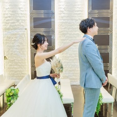 ファーストミートで新郎の肩をたたく新婦の写真