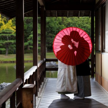 赤い和傘越しでオシャレなお二人のシルエット