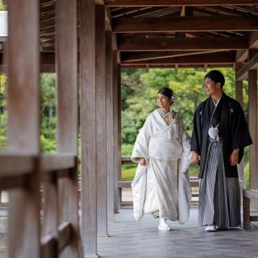 フォトウェディングで訪れた大仙公園にて、渡り廊下を手つないで歩くお二人