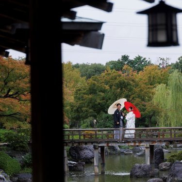 大仙公園にて、庭園の橋で和傘をさすお2人。大阪の和装ロケーション前撮り
