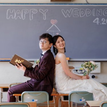 背中を合わせてニッコリ笑顔、ふたりの記念に残す結婚写真