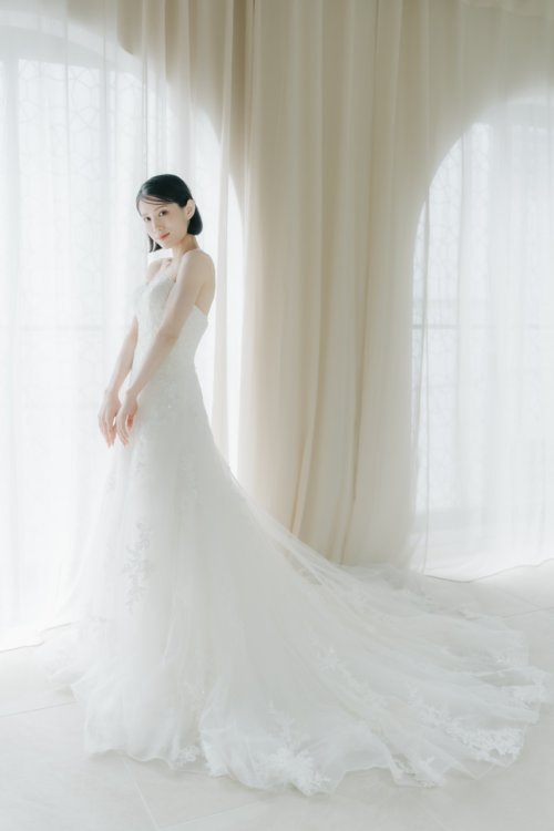 スレンダーAラインのウェディングドレスをまとった花嫁。すらりと縦に流れるシルエットが美しい大阪心斎橋店の前撮り（衣装番号OR01）