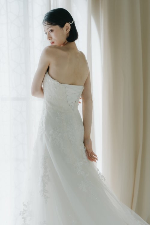 上品な光沢のスレンダーAラインドレスで見せる花嫁の立ち姿。大阪の結婚写真撮影より（衣装番号OR01）
