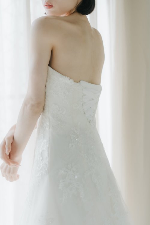 レースのトレーンを広げて佇む新婦。洋装前撮りならではの優雅なシルエット（大阪心斎橋店／衣装番号OR01）