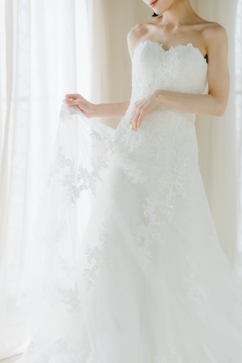 歩くたびに揺れるレーストレーンが印象的なウェディングドレス姿。心斎橋店のフォト婚（衣装番号OR01）