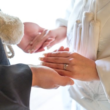 慶沢園にて、白無垢の袖の前でそっと重ねた新郎新婦の手と婚約指輪のクローズアップ、和装前撮りのディテールカット