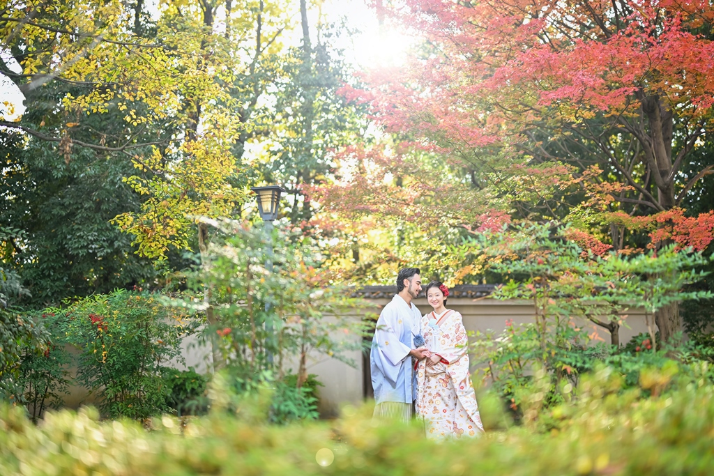 木漏れ日が差す紅葉の庭園で寄り添う新郎新婦。藤田邸跡公園で撮る色打掛と羽織袴のフォトウェディング
