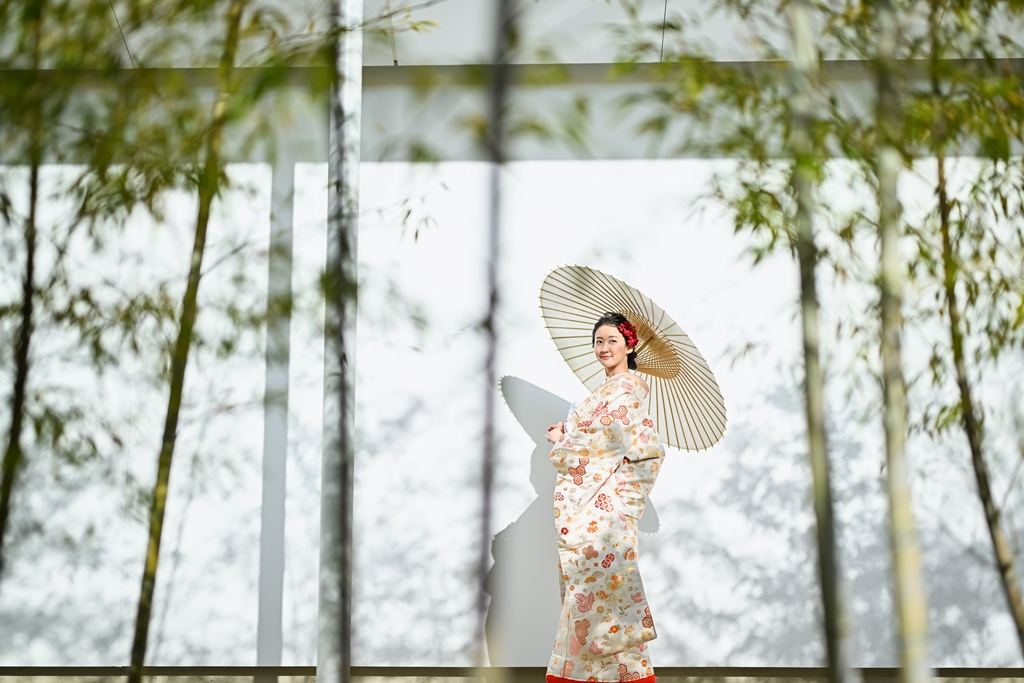 竹林を背景に白い和傘を差して振り返る色打掛の花嫁。藤田邸跡公園で撮るフォトウェディング