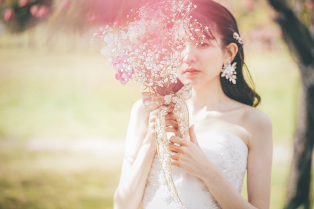 公園の自然に映えるウェディングドレス姿の新婦