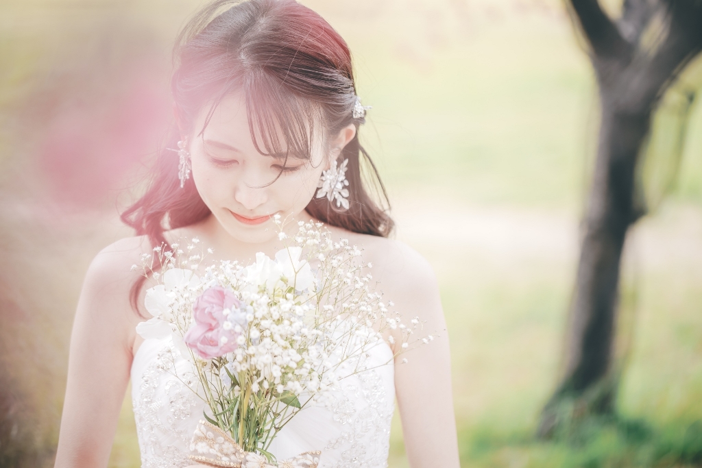 公園の自然に映えるウェディングドレス姿の新婦