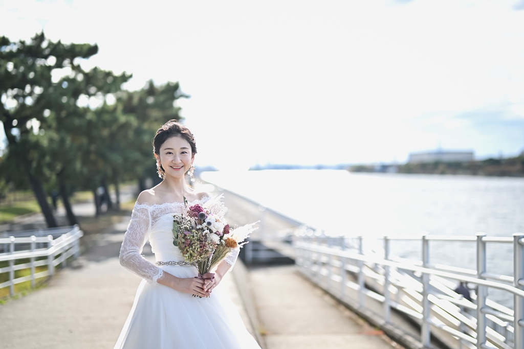 海沿いの遊歩道で微笑む花嫁