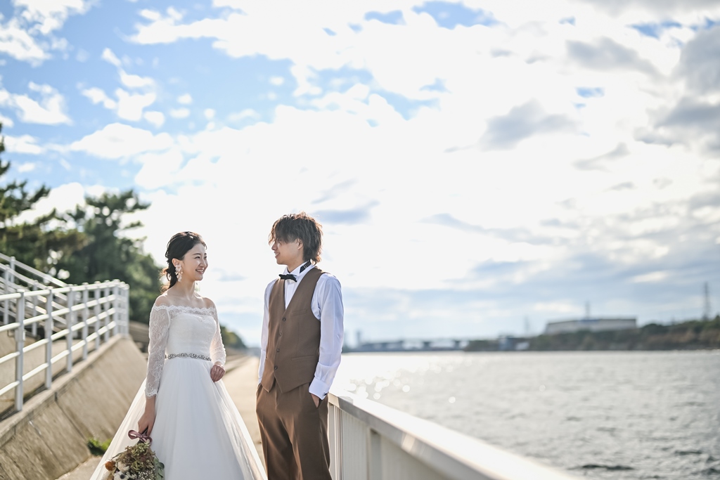 海沿いのフェンス際で見つめ合うふたり