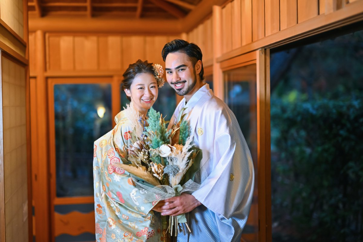 廊下でブーケを手に寄り添う新郎新婦のツーショット