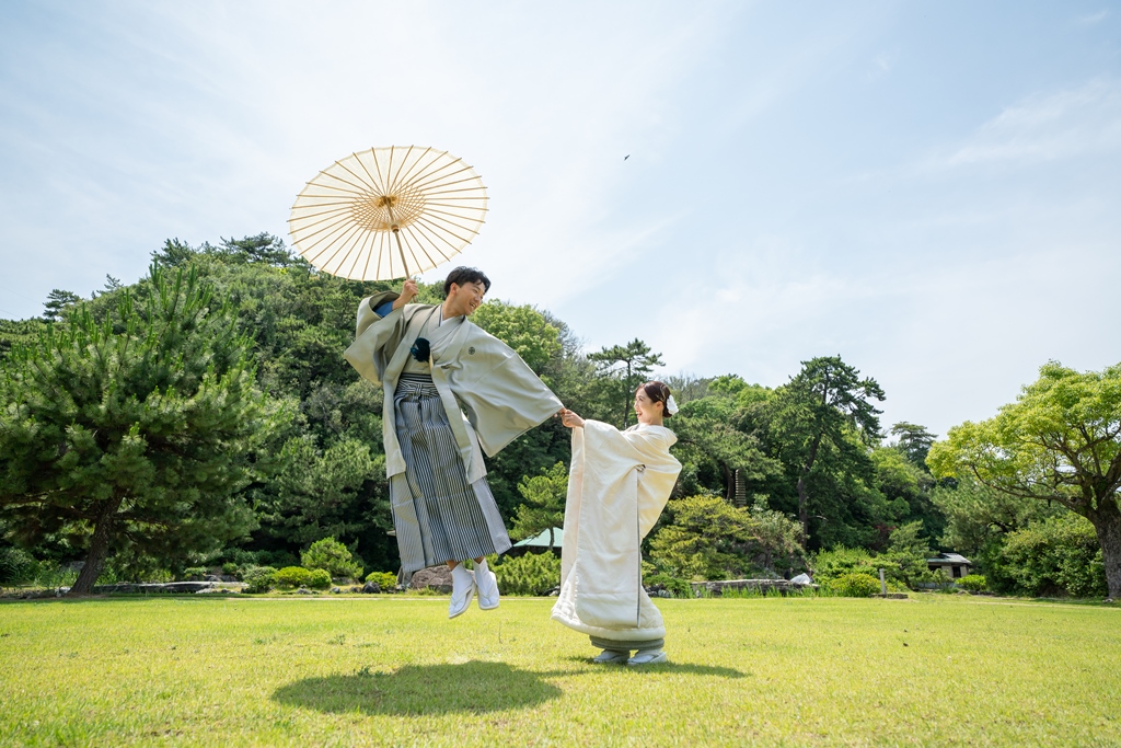 芝生の庭園で笑い合う新郎新婦
