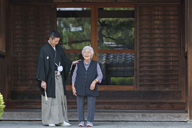 おじいちゃんおばあちゃんとお孫さんが手をつないでいる様子