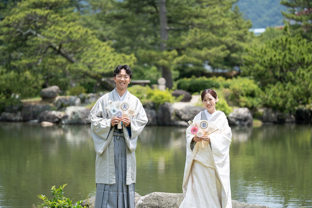 大池のほとりで佇む新郎新婦