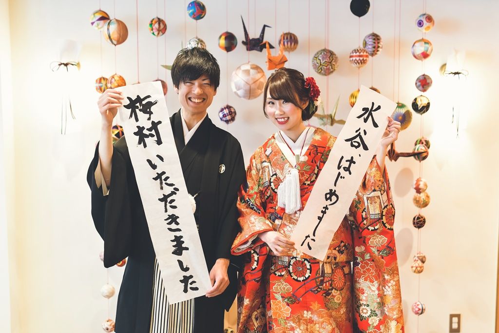習字の紙を持って撮影している写真