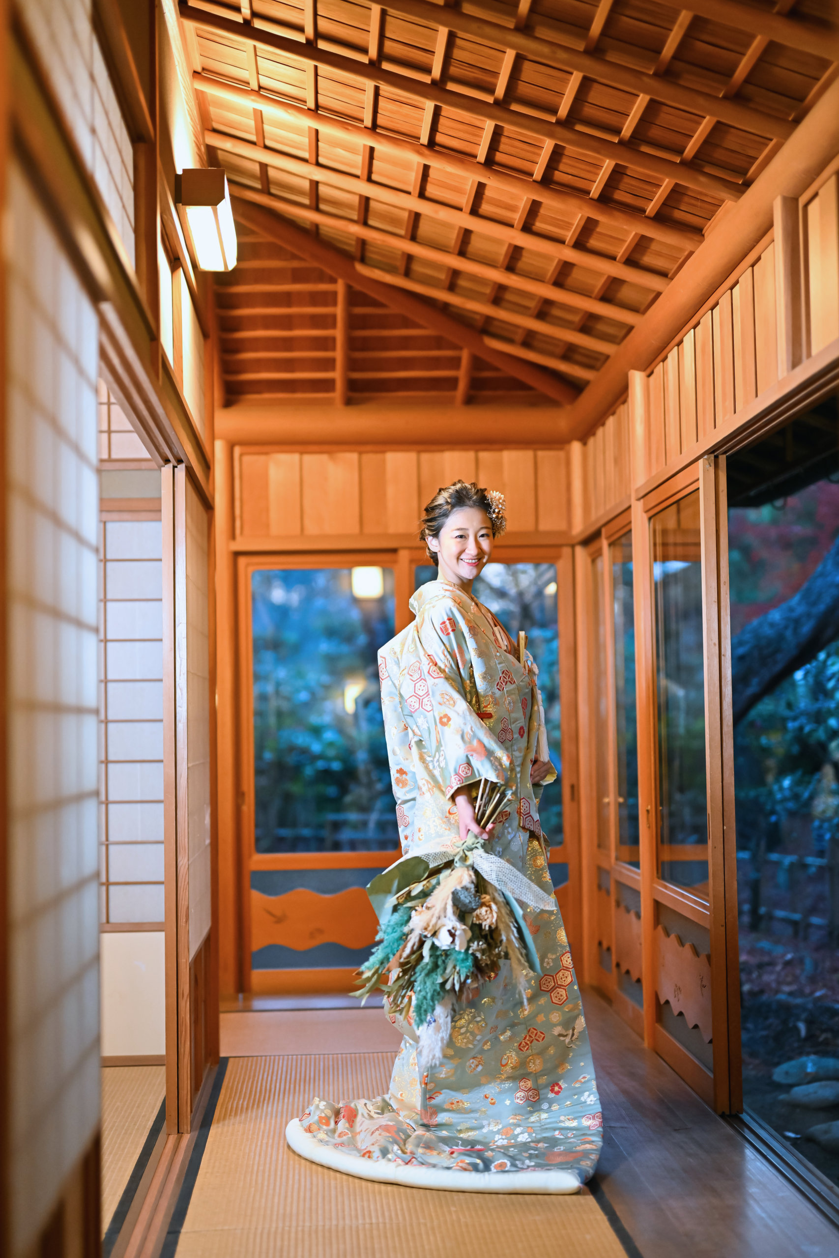 奥行きのある廊下に佇む新郎新婦の後ろ姿を含む一枚