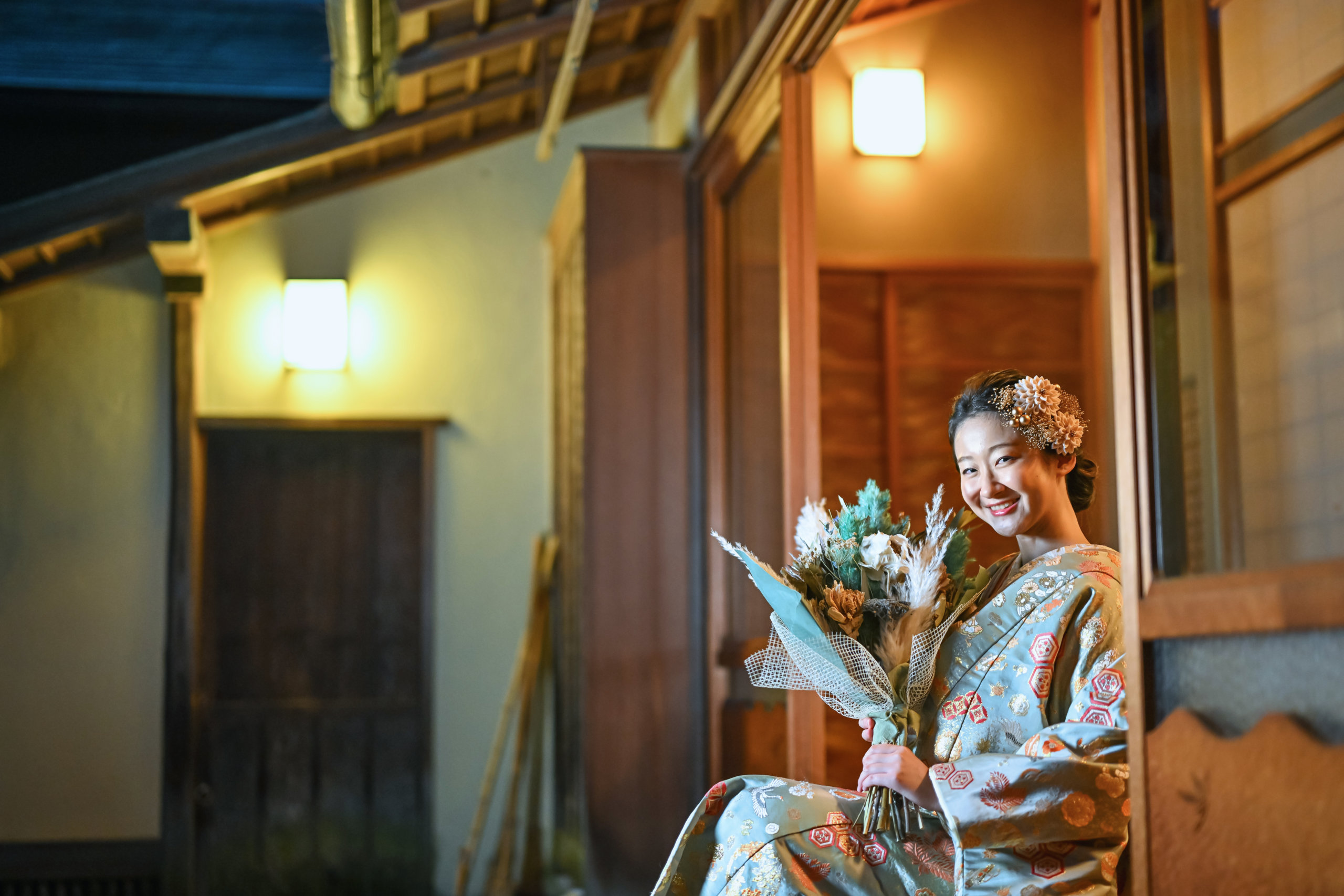 奥行きのある廊下に佇む新郎新婦の後ろ姿を含む一枚