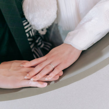 白無垢の袖の上で重ねた新郎新婦の手と結婚指輪のクローズアップ、和装前撮りのディテールカット