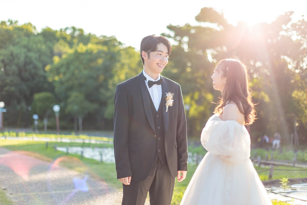 水辺で撮影する新郎新婦