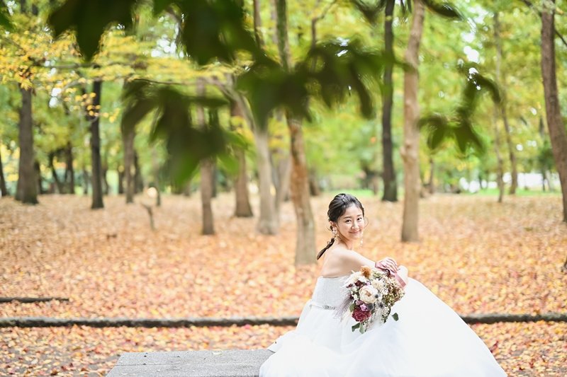 ベンチに座っているウェディングドレスを来た花嫁の写真