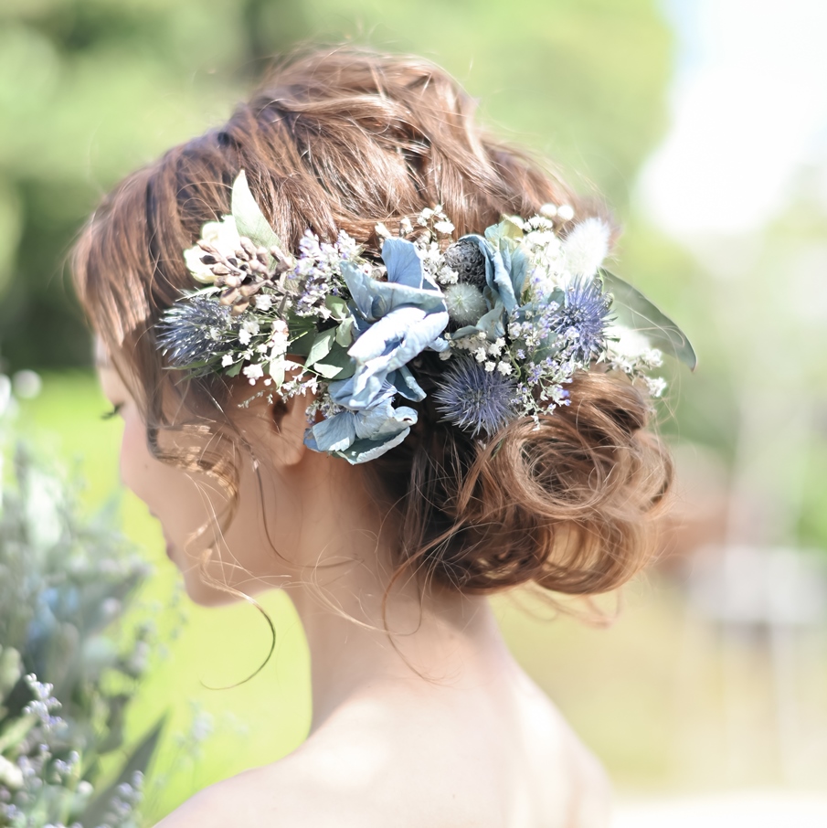 ブルー系のドライフラワーとかすみ草を飾った、抜け感のあるまとめ髪ヘアメイク
