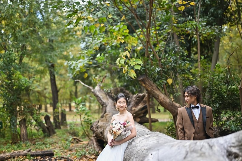 緑の中にいる洋装姿の新郎新婦