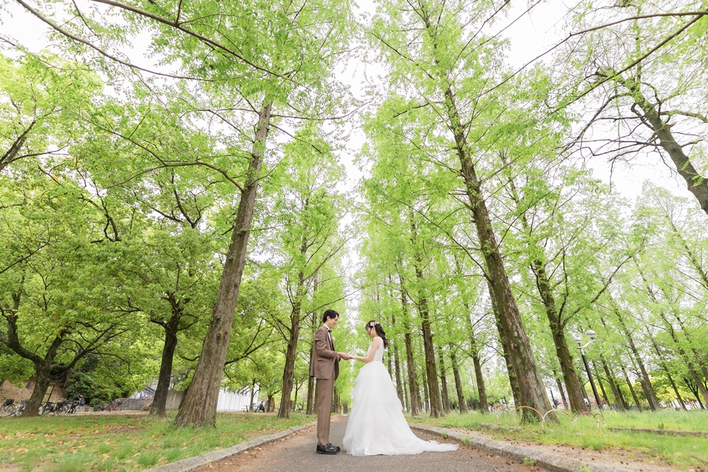 木漏れ日の並木道を歩く新郎新婦