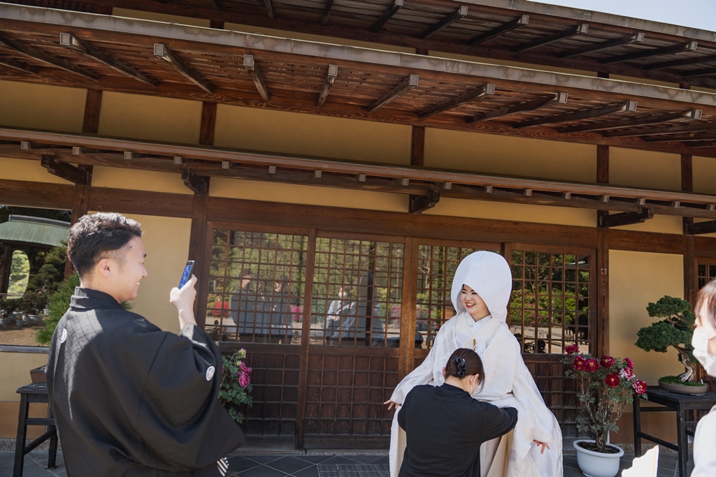 撮影の合間に笑顔で会話する新郎新婦のオフショット