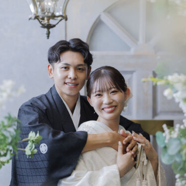 アンティーク扉の前で、新郎が白無垢の花嫁を後ろから抱きしめて笑うハグポーズの和装フォトウェディング