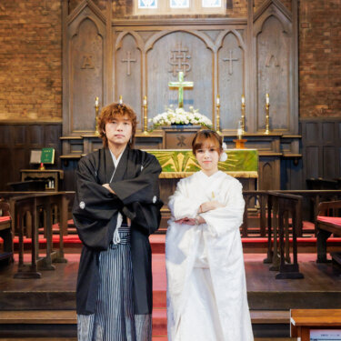 大阪の川口基督教会の祭壇の前で、そろって腕を組んで立つ紋付袴の新郎と白無垢の花嫁。チャペルで撮る和装前撮りのかっこいいポーズ